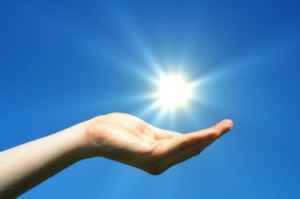 hand sun and blue sky showing hope peace or freedom concept