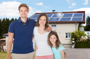 39119623 - family standing in front house with solar panel on roof